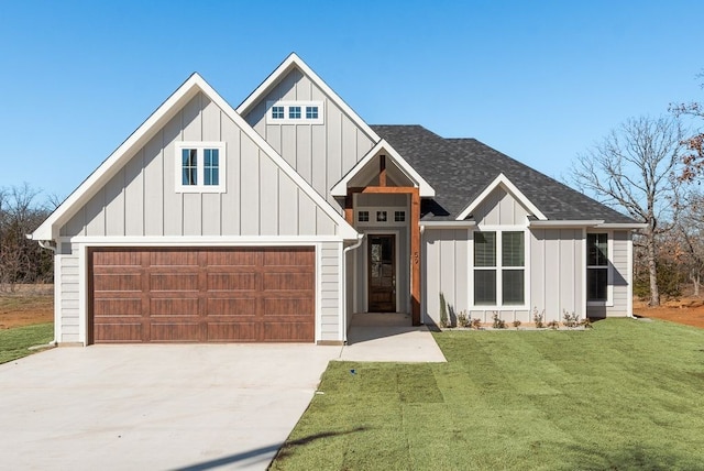 modern farmhouse style home with a front yard, board and batten siding, and driveway