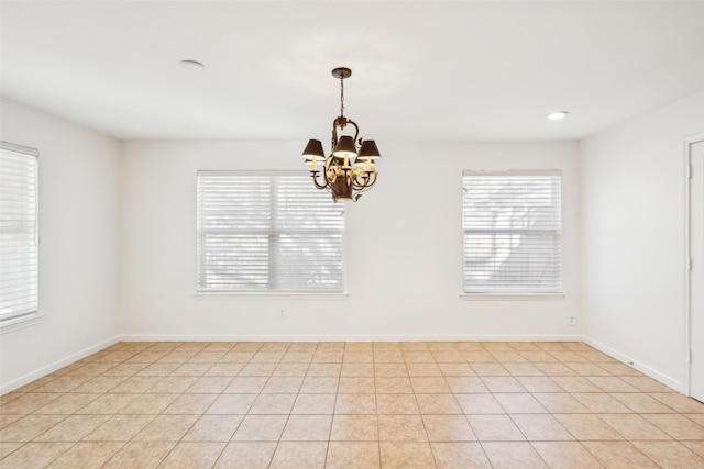 unfurnished room featuring recessed lighting, baseboards, plenty of natural light, and a notable chandelier