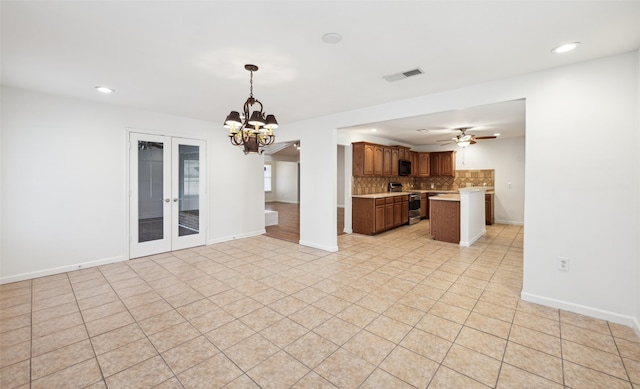 unfurnished living room featuring visible vents, ceiling fan with notable chandelier, recessed lighting, light tile patterned flooring, and baseboards