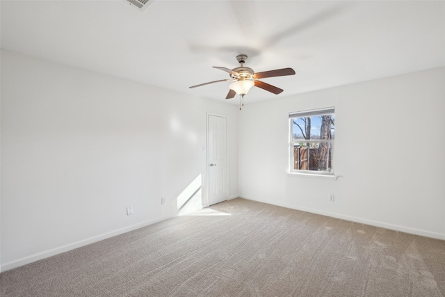 carpeted spare room with baseboards and ceiling fan