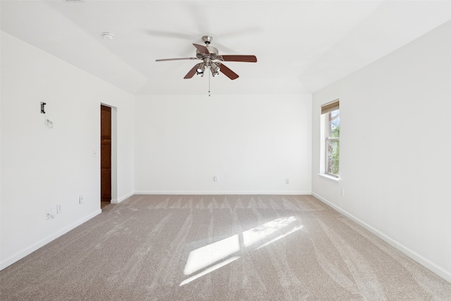 unfurnished room with baseboards, carpet floors, and a ceiling fan