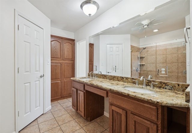 bathroom with tile patterned flooring, tiled shower, a ceiling fan, and a sink