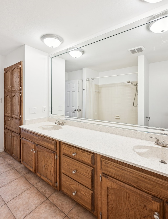 bathroom featuring tile patterned flooring, double vanity, visible vents, and a sink