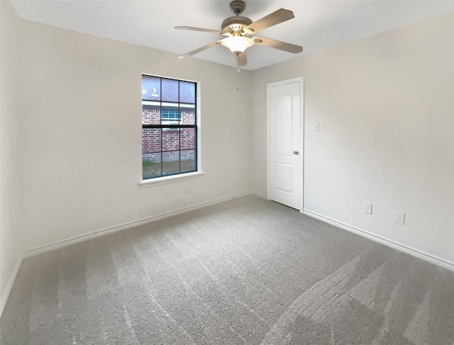 spare room featuring a ceiling fan, baseboards, and carpet floors