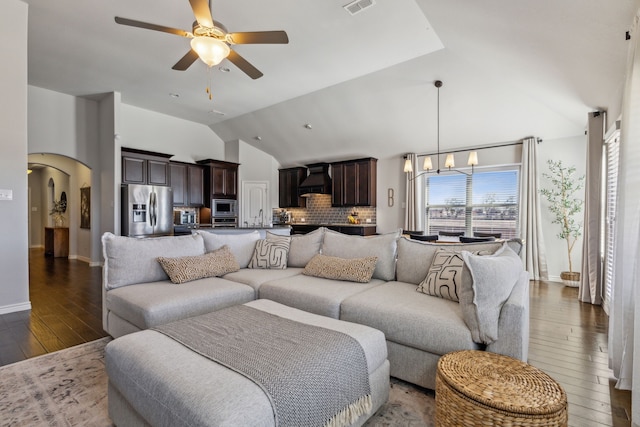 living area featuring visible vents, high vaulted ceiling, ceiling fan with notable chandelier, hardwood / wood-style floors, and arched walkways