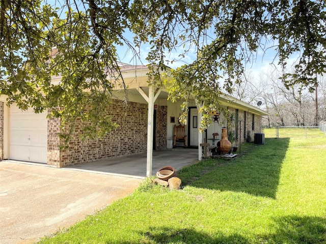 view of front of house featuring a front yard, fence, driveway, central AC, and brick siding