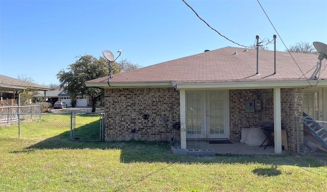 rear view of property with brick siding, fence, french doors, a yard, and a gate