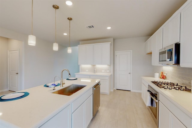 kitchen with visible vents, appliances with stainless steel finishes, light countertops, and a sink