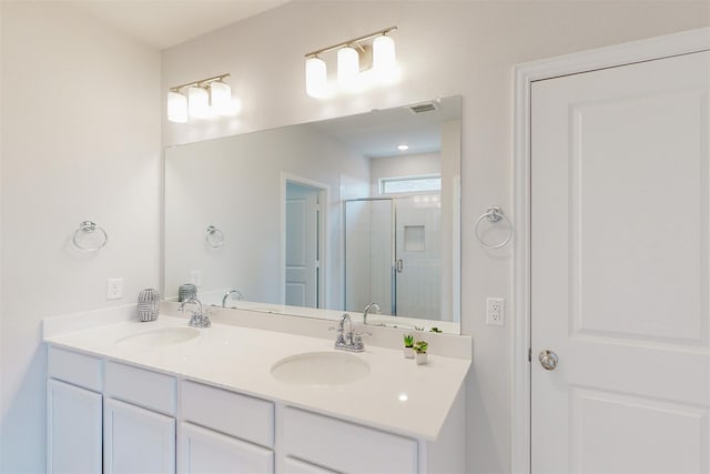 bathroom featuring double vanity, visible vents, a shower stall, and a sink