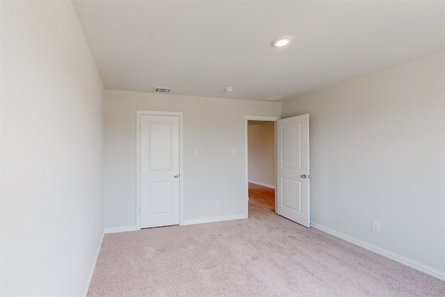 carpeted empty room with visible vents and baseboards