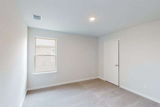 spare room with visible vents, carpet floors, and baseboards