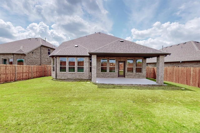 back of property featuring a fenced backyard, a yard, a shingled roof, and a patio