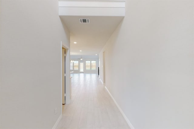 corridor with recessed lighting, visible vents, light wood-style flooring, and baseboards