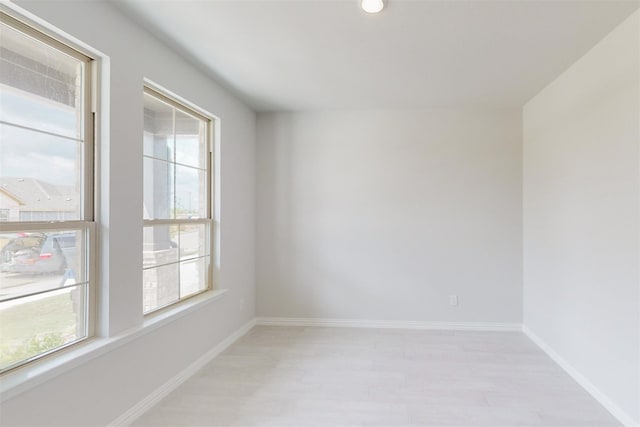 empty room with light wood-style floors and baseboards