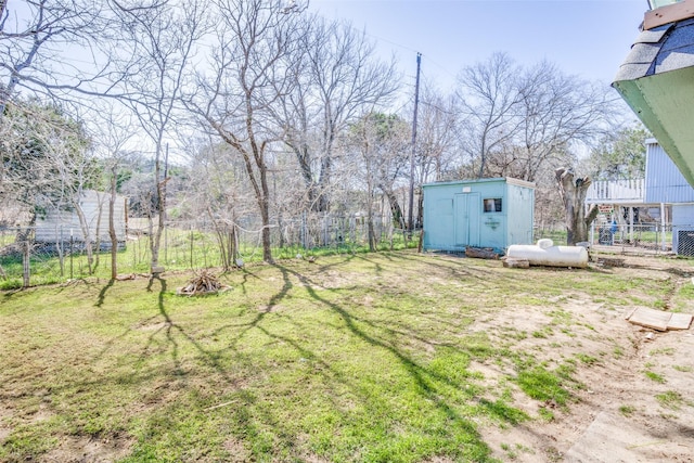 view of yard with an outbuilding, a storage shed, and fence