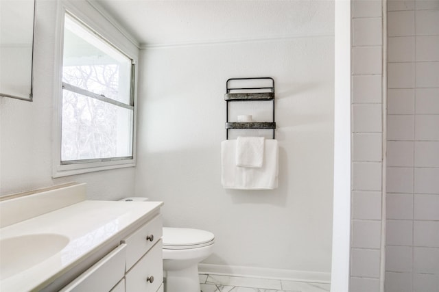 bathroom with marble finish floor, toilet, vanity, and baseboards