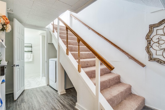 staircase with washer / dryer and wood finished floors