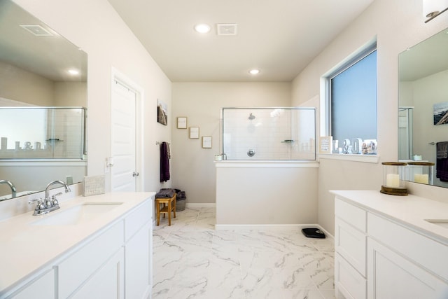 full bath with baseboards, a stall shower, marble finish floor, and a sink