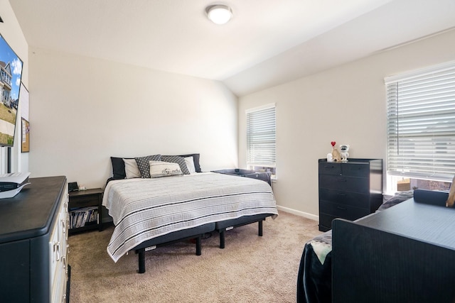 bedroom with light colored carpet, baseboards, and vaulted ceiling