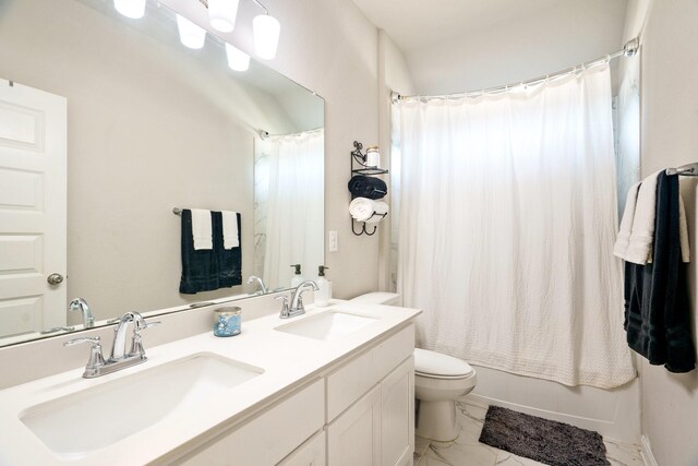 bathroom featuring a sink, toilet, marble finish floor, and double vanity