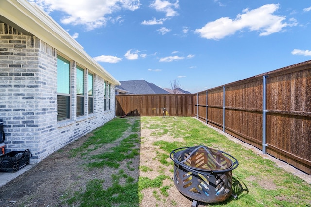 view of yard featuring a fire pit and a fenced backyard