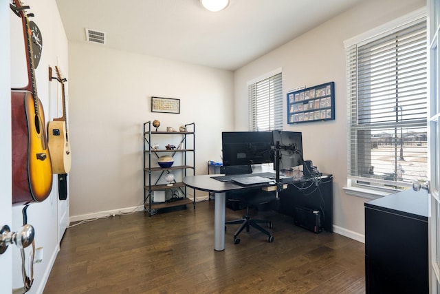 office space with dark wood-style floors, visible vents, and baseboards