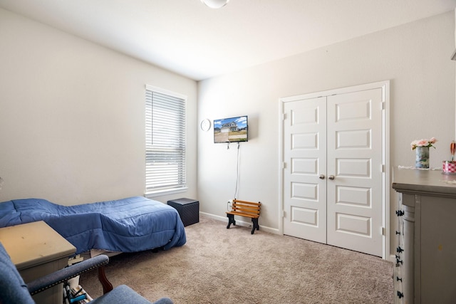 bedroom with a closet, baseboards, and carpet