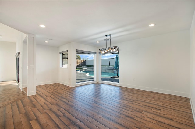 empty room featuring dark wood finished floors, recessed lighting, and baseboards