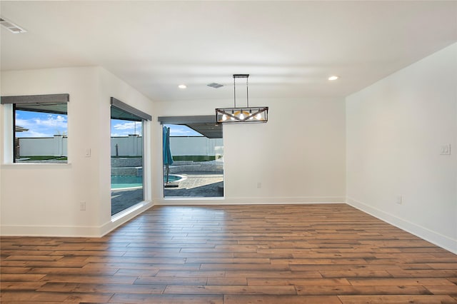 unfurnished dining area featuring recessed lighting, visible vents, baseboards, and wood finished floors