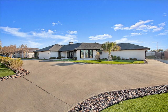 view of front of house with a front yard, driveway, and fence