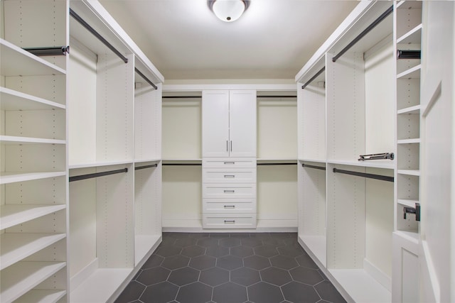 walk in closet with dark tile patterned flooring