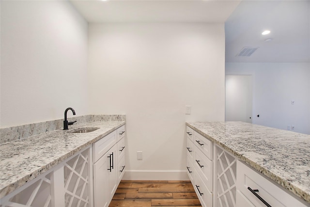 bathroom featuring visible vents, baseboards, recessed lighting, wood finished floors, and vanity