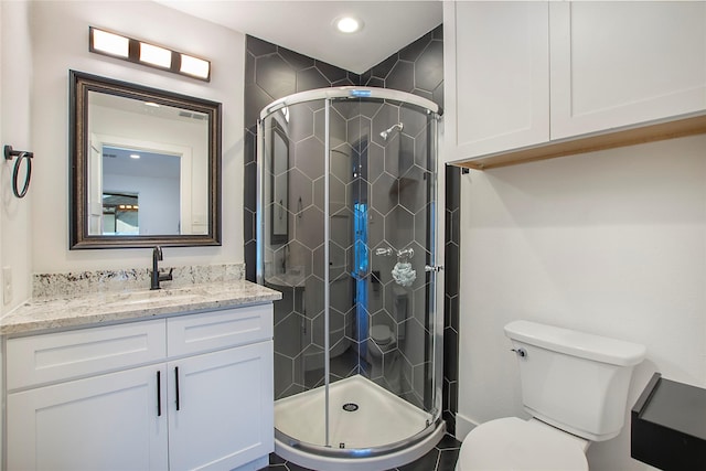 full bathroom featuring a shower stall, vanity, and toilet