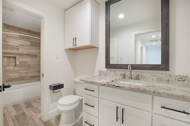 bathroom with wood finish floors, visible vents, toilet, and vanity