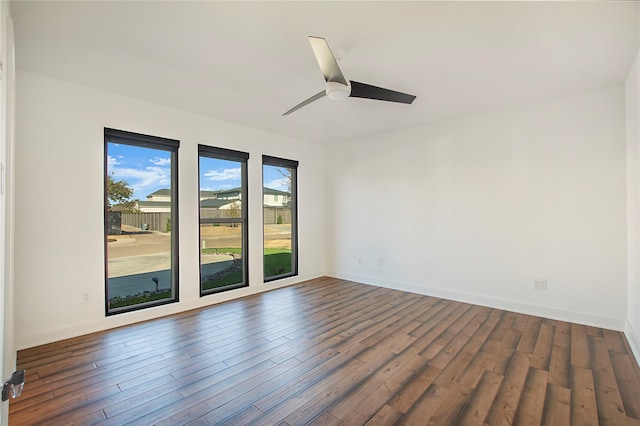 unfurnished room featuring baseboards, ceiling fan, and dark wood-style flooring