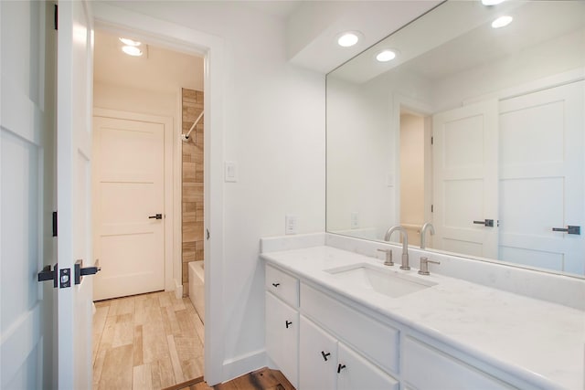 full bathroom featuring tub / shower combination, baseboards, recessed lighting, wood finished floors, and vanity