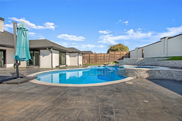 view of swimming pool with a pool with connected hot tub, a patio area, and a fenced backyard