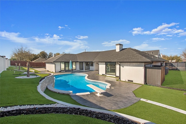 view of swimming pool with a patio, a fenced backyard, a yard, a diving board, and a fenced in pool