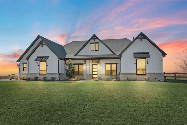 modern farmhouse style home with a lawn, board and batten siding, and roof with shingles