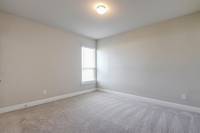 spare room with carpet flooring and baseboards