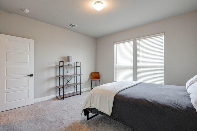 bedroom featuring baseboards, visible vents, and carpet