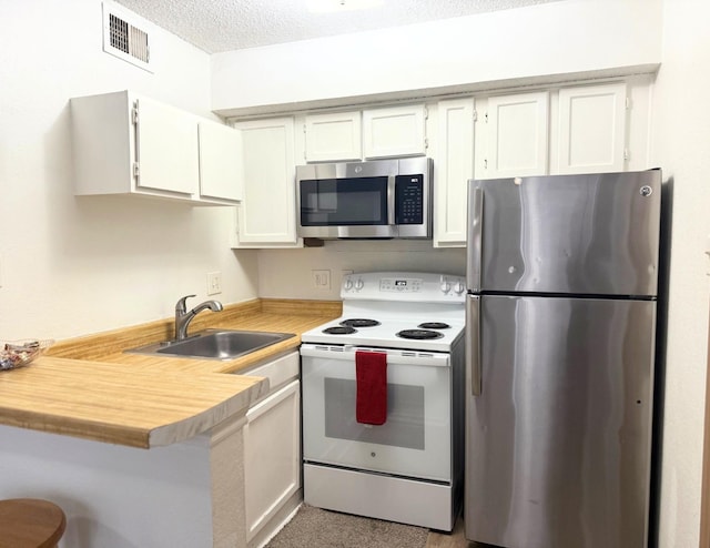 kitchen with visible vents, a sink, light countertops, appliances with stainless steel finishes, and white cabinetry