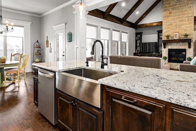 kitchen with beamed ceiling, a sink, stainless steel dishwasher, dark wood-style floors, and a fireplace