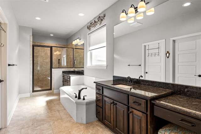 bathroom featuring baseboards, two vanities, a stall shower, a bath, and a sink