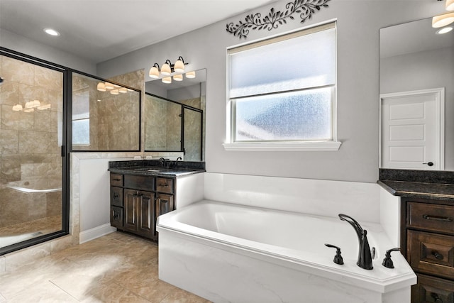 bathroom featuring vanity, a shower stall, and a garden tub