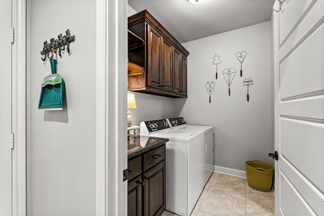 laundry room featuring light tile patterned floors, baseboards, cabinet space, and separate washer and dryer