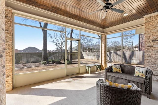 sunroom with a wealth of natural light, wood ceiling, and ceiling fan