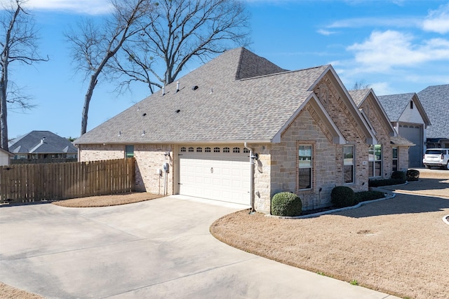 view of home's exterior featuring a garage, driveway, roof with shingles, and fence