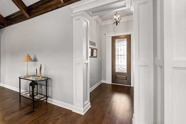 foyer featuring dark wood finished floors, baseboards, crown molding, and ornate columns