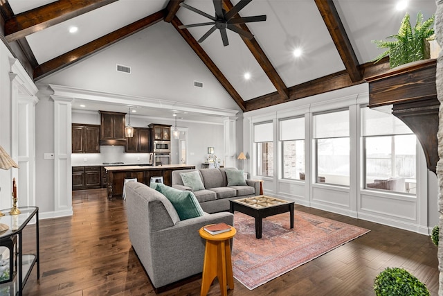 living area featuring dark wood finished floors, visible vents, ceiling fan, and decorative columns